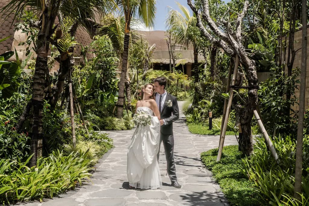 Couple strolling along a tropical garden path at Equipoise